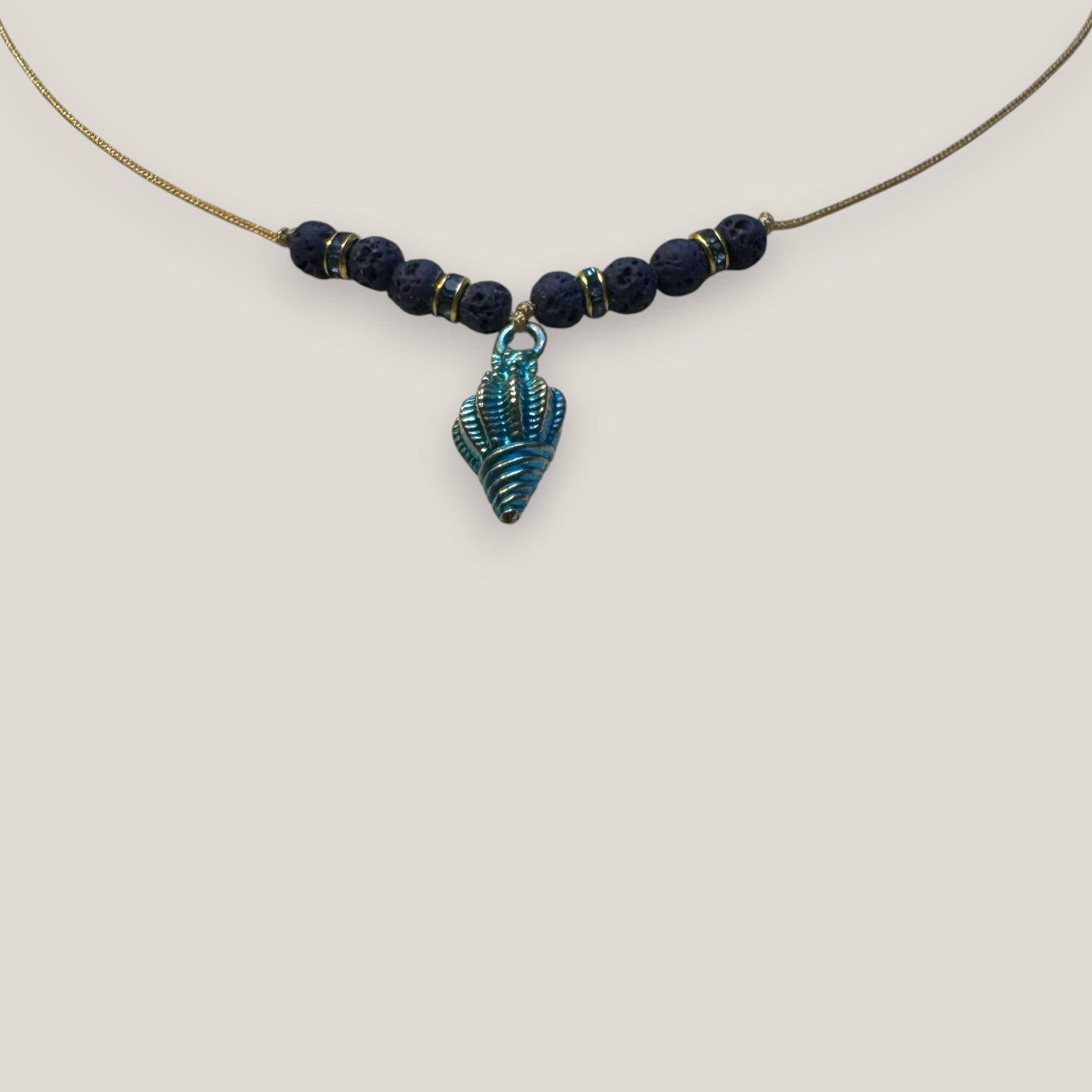 Collar midi con caracola dorada esmaltada en azul oscuro con lava azul oscuro y separadores dorados con cristalitos azules oscuro
