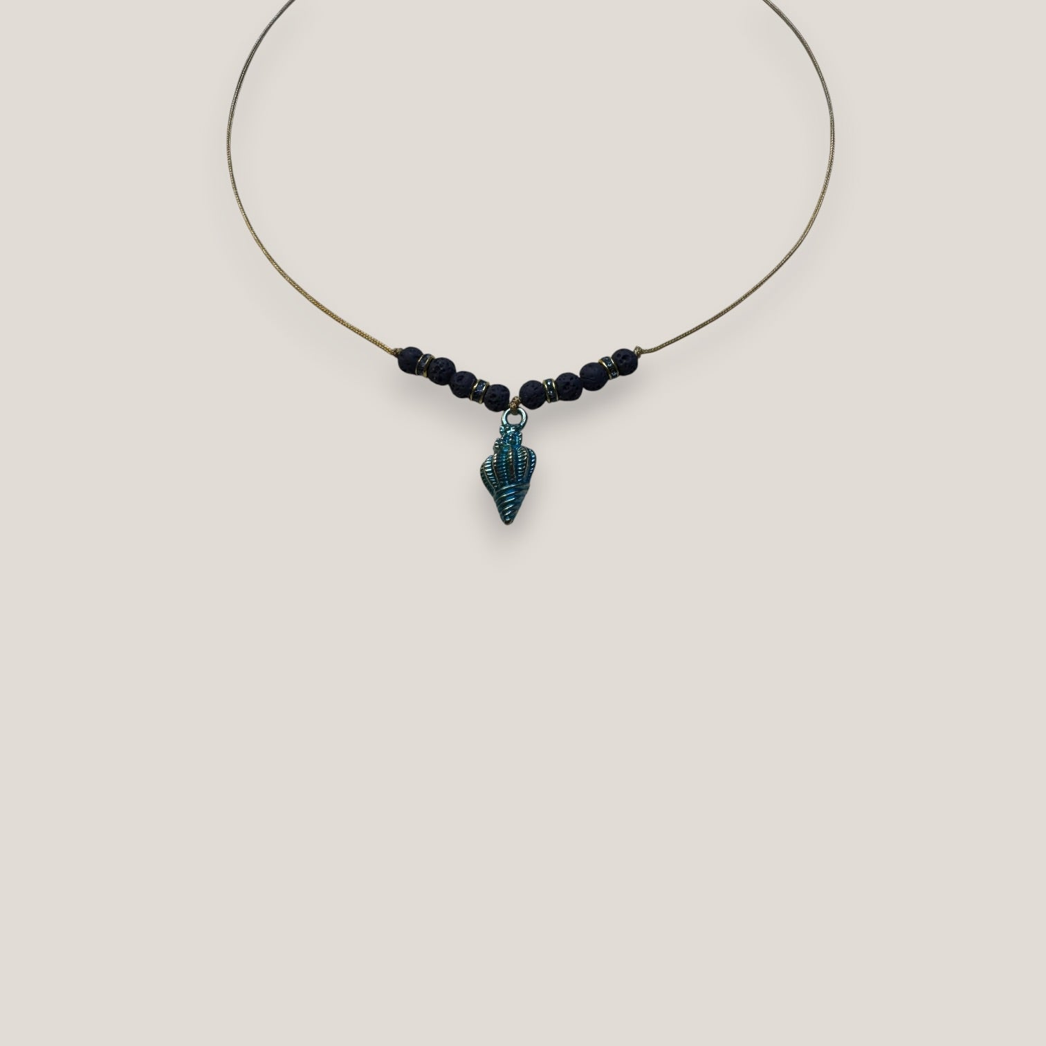 Collar midi con caracola dorada esmaltada en azul oscuro con lava azul oscuro y separadores dorados con cristalitos azules oscuro
