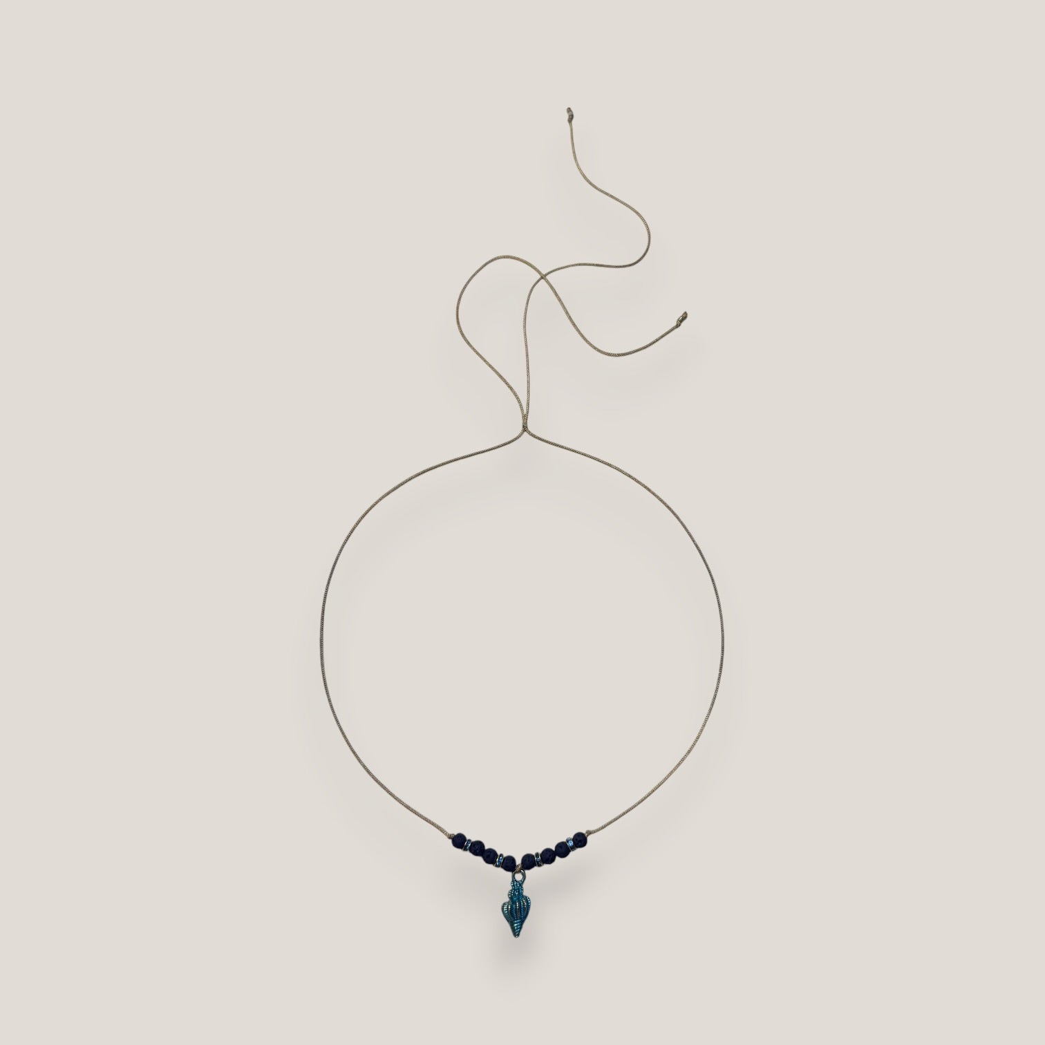 Collar midi con caracola dorada esmaltada en azul oscuro con lava azul oscuro y separadores dorados con cristalitos azules oscuro