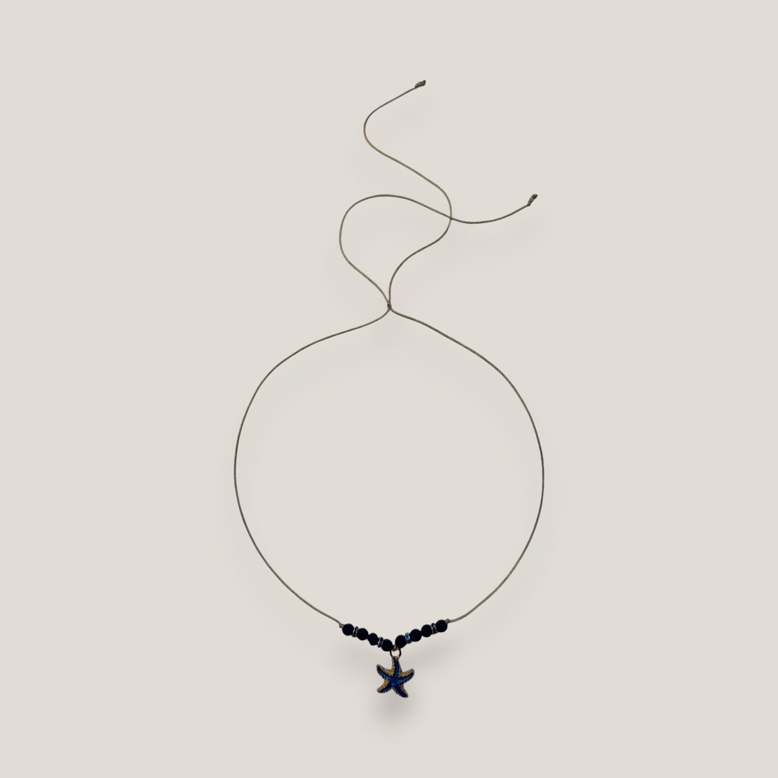 Collar midi con estrella dorada esmaltada en azul marino con lava azul oscuro y separadores dorados con cristalitos azules oscuro