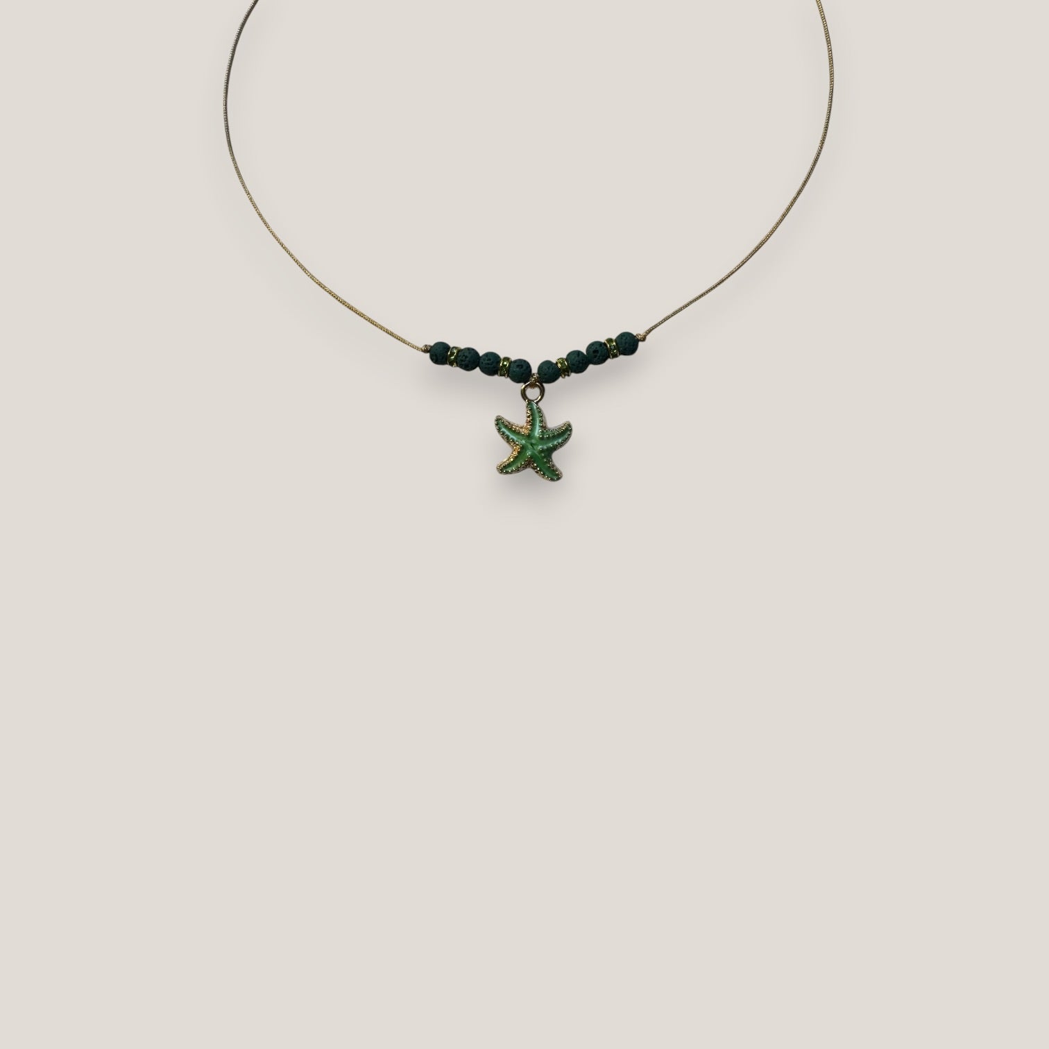 Collar midi con estrella dorada esmaltada en verde con lava verde oscuro y separadores dorados con cristalitos verde olivina