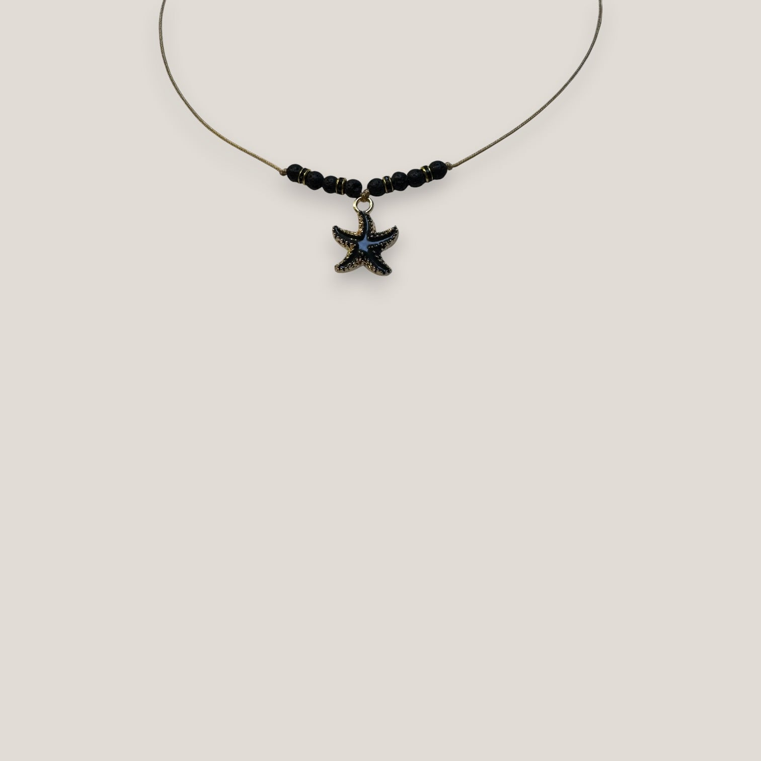 Collar midi con estrella dorada esmaltada en negro lava negra y separadores dorados con cristalitos negros