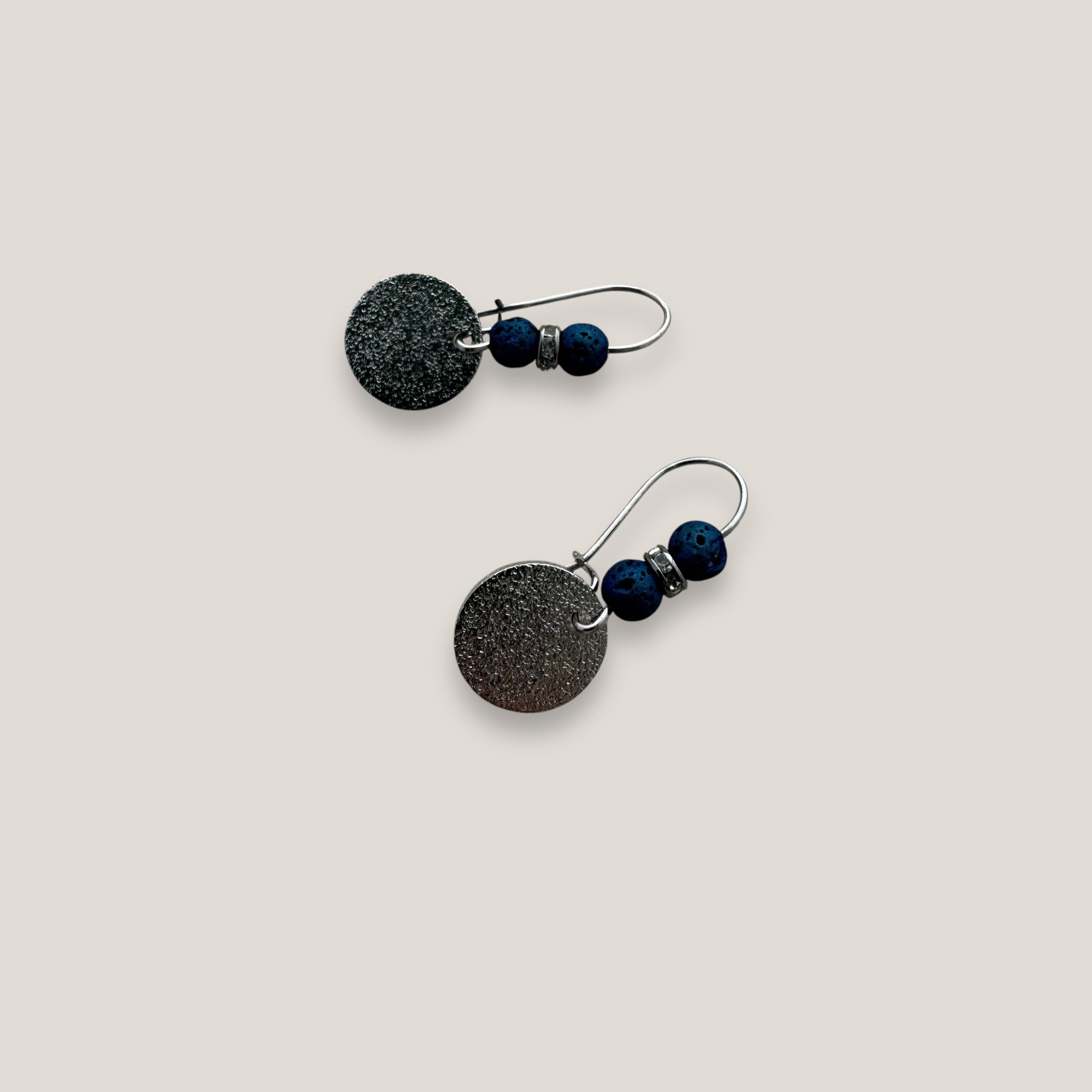 Pendientes Dafne gancho 20mm con medalla martilleada 10mm plata, lava 4mm azul añil y disco gunmetal con cristales blancos