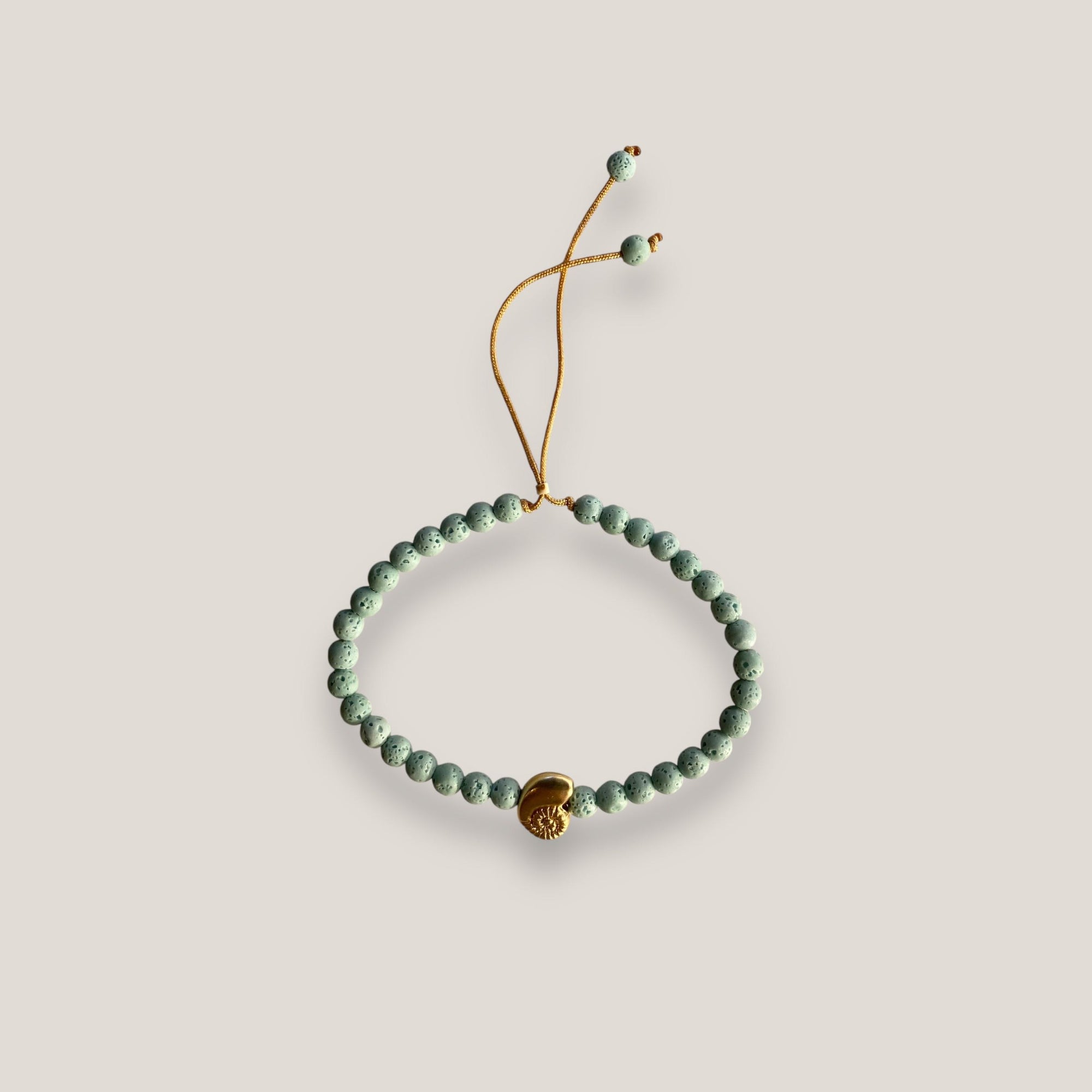 Pulsera con caracola dorada y esponja coral turquesa