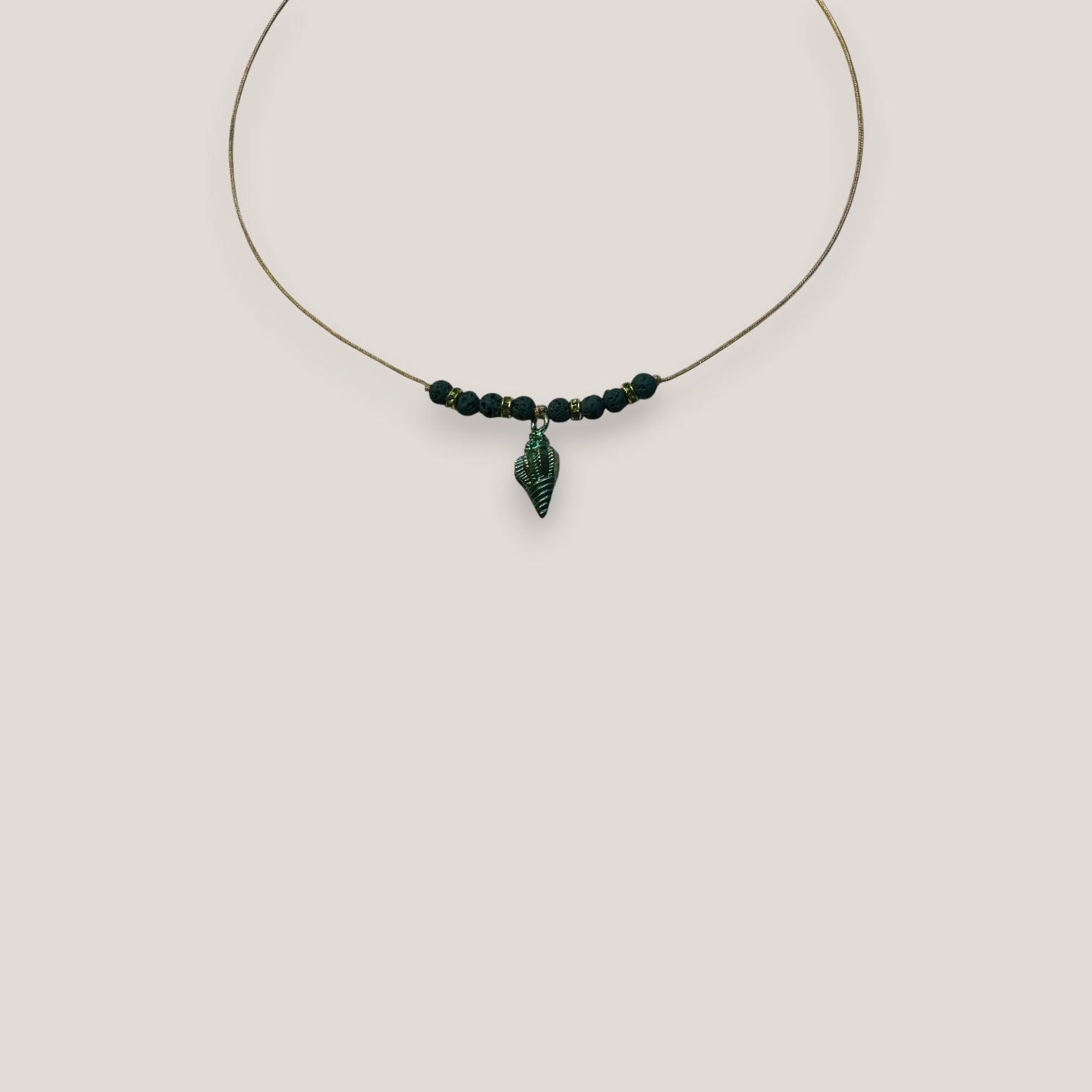 Collar midi con caracola dorada esmaltada en verde con lava verde oscuro y separadores dorados con cristalitos verde olivina