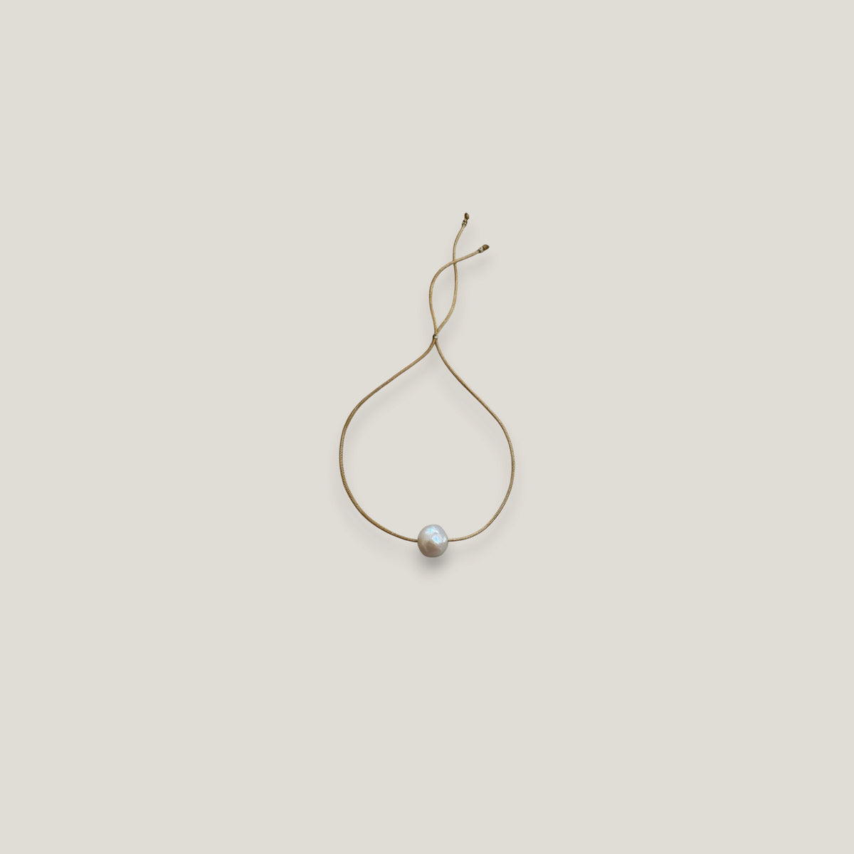Pulsera minimal perla natural redondeada 10mm blanca cordón nailon dorado