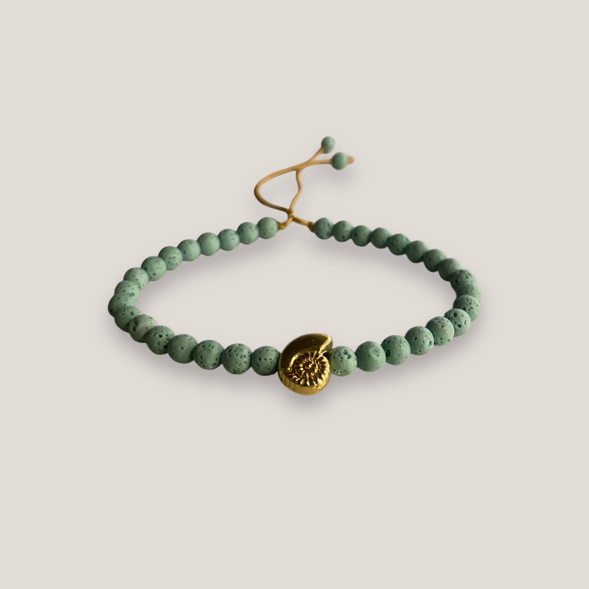 Pulsera con caracola dorada y esponja coral turquesa