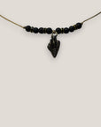 Collar midi con caracola dorada esmaltada en negro lava negra y separadores dorados con cristalitos negros