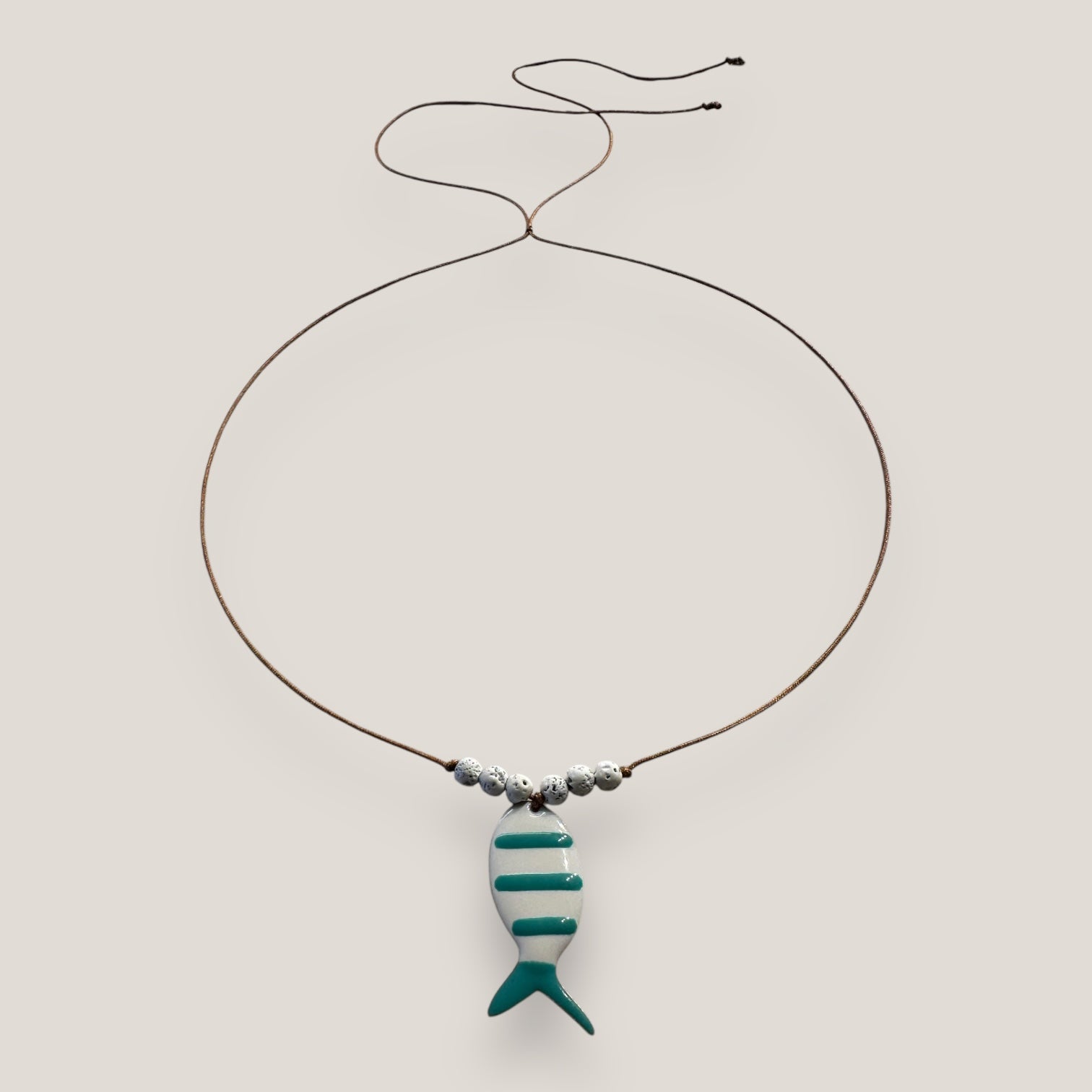 Collar midi pez esmaltado blanco con rayas verde turquesa y cuentas de lava blancas