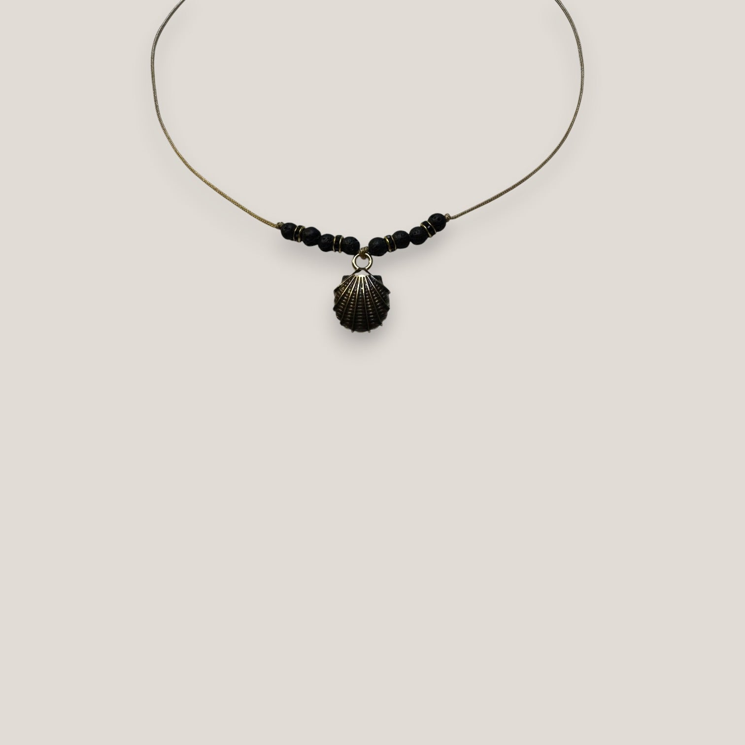 Collar midi con concha dorada esmaltada en negro lava negra y separadores dorados con cristalitos negros