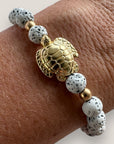 Pulsera con gran tortuga dorada y lava blanca