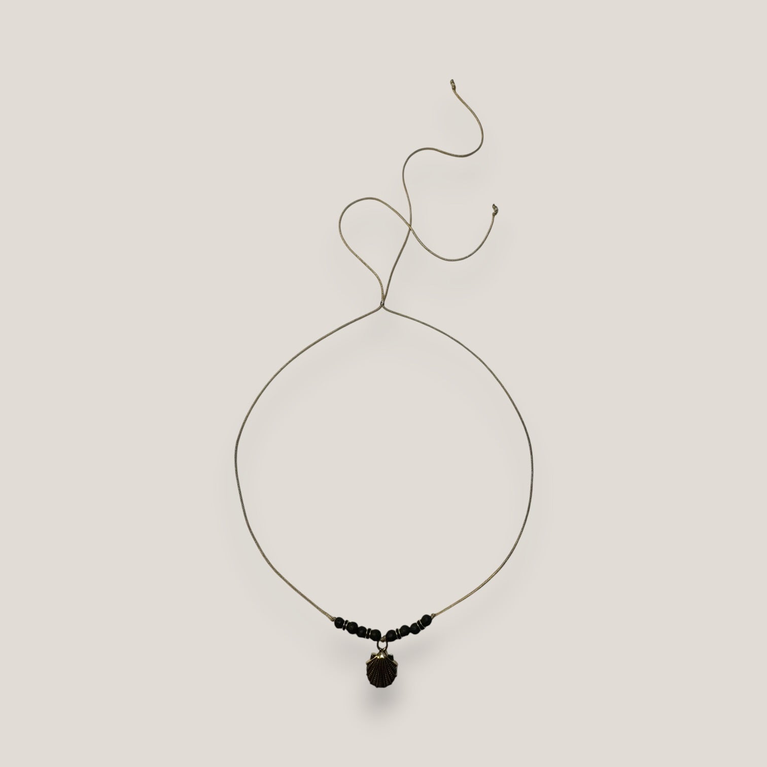 Collar midi con concha dorada esmaltada en negro lava negra y separadores dorados con cristalitos negros