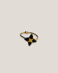 Goldener Ring mit vierzackigem Stern und schwarzem Onyxstein aus Stahl und Gold.