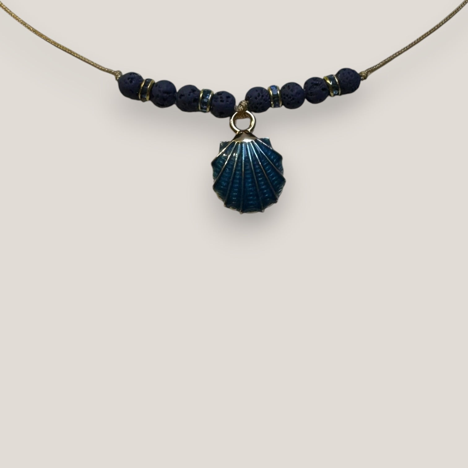 Collar midi con concha dorada esmaltada en azul marino con lava azul oscuro y separadores dorados con cristalitos azules oscuro