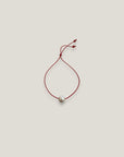 Pulsera minimal perla natural redondeada 10mm blanca cordón nailon rojo