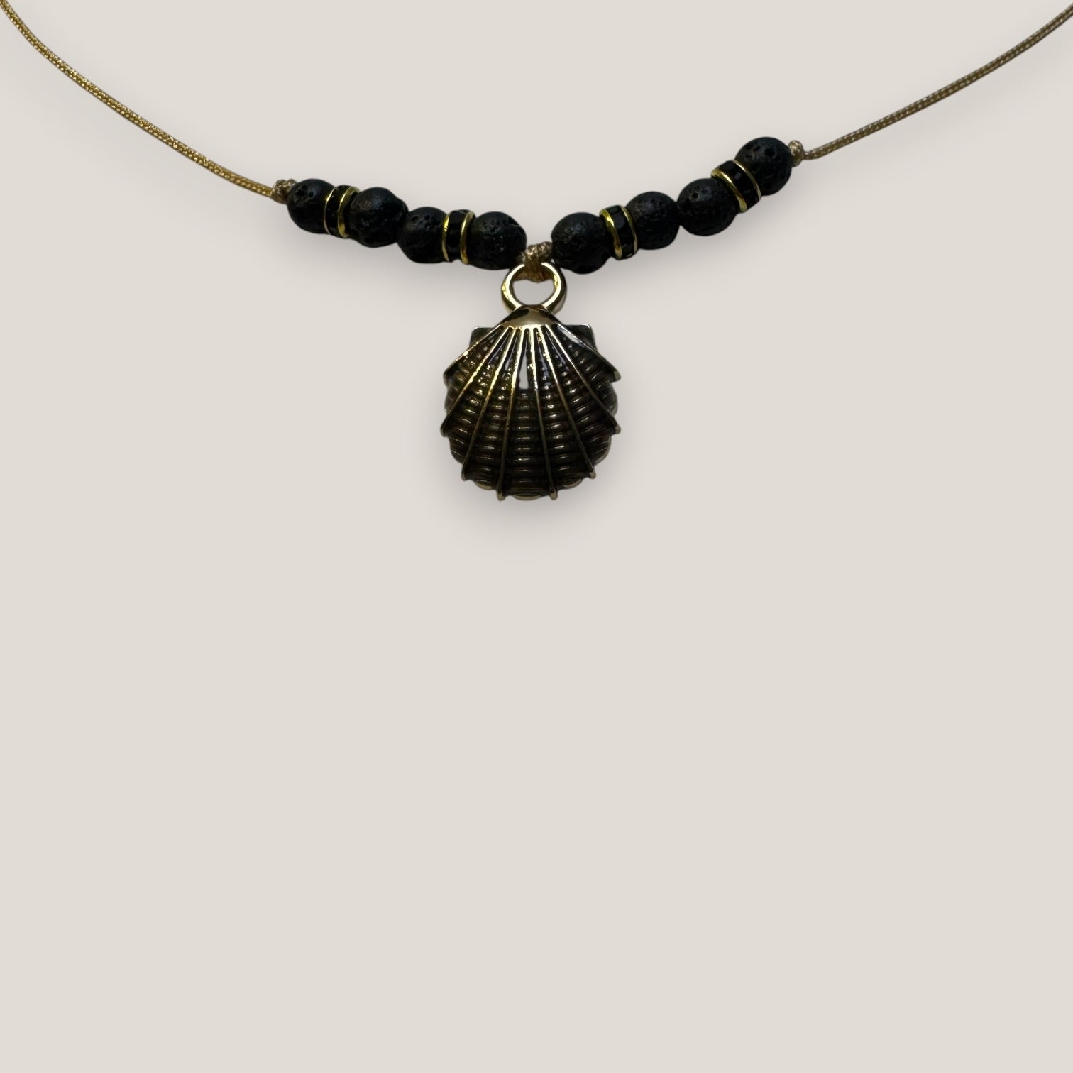Collar midi con concha dorada esmaltada en negro lava negra y separadores dorados con cristalitos negros