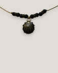 Collar midi con concha dorada esmaltada en negro lava negra y separadores dorados con cristalitos negros