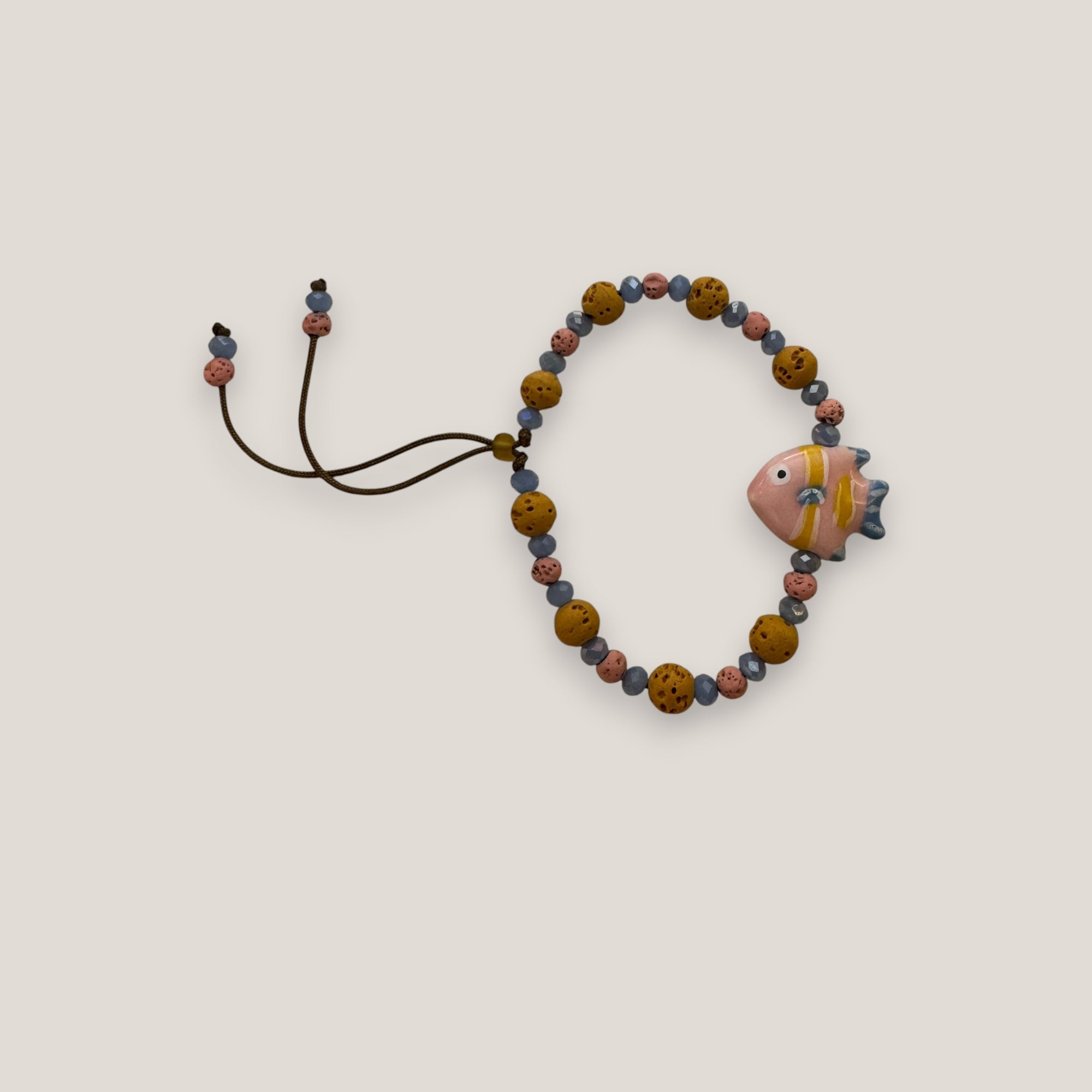 Pulsera pez rosa azul amarillo esponja coral naranja oscuro lava rosa y cristales facetados azul claro