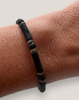 Pulsera con tubos y cuentas de lava negra y brillis gunmetal con cristalitos blancos