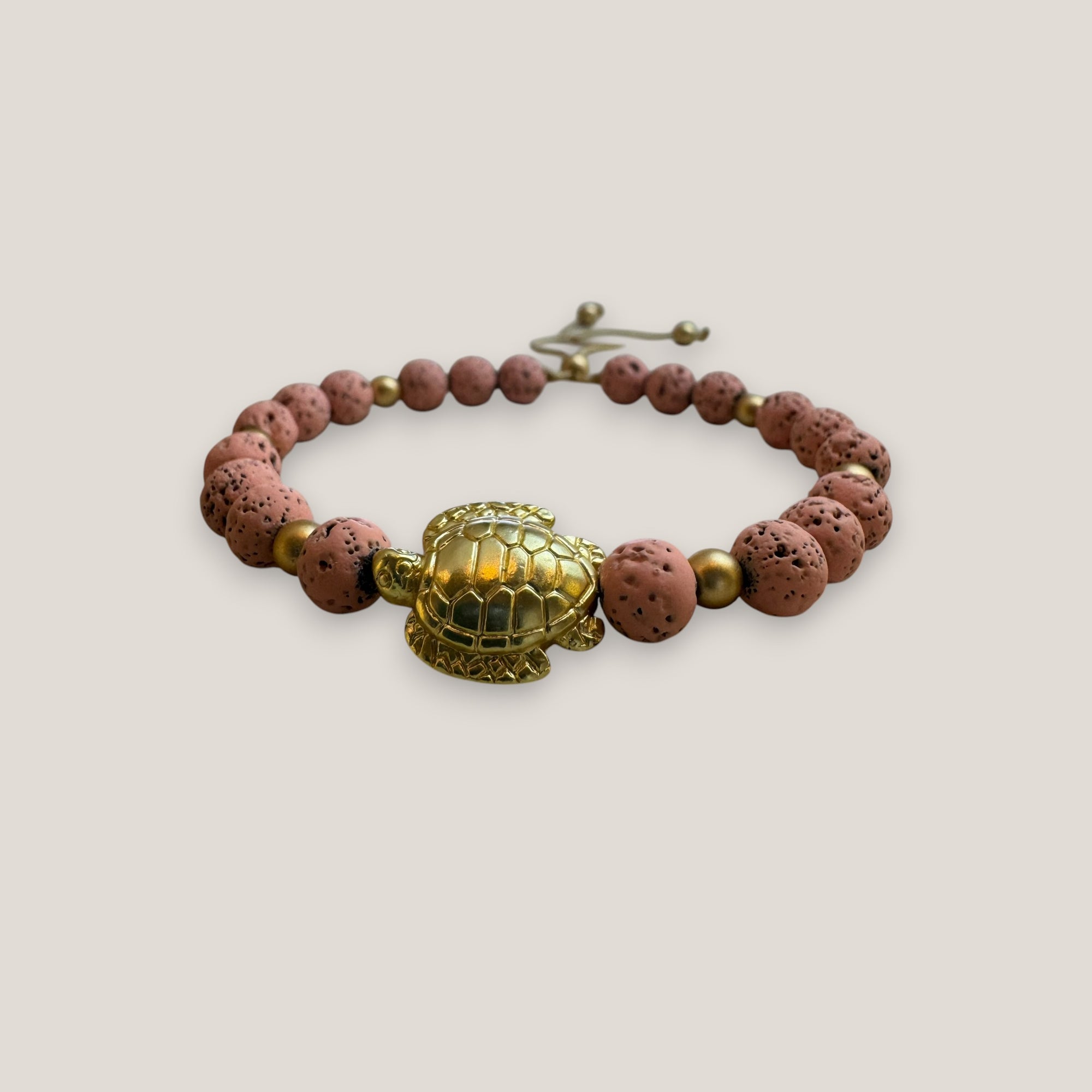 Armband mit großer goldener Schildkröte und rosa Lava