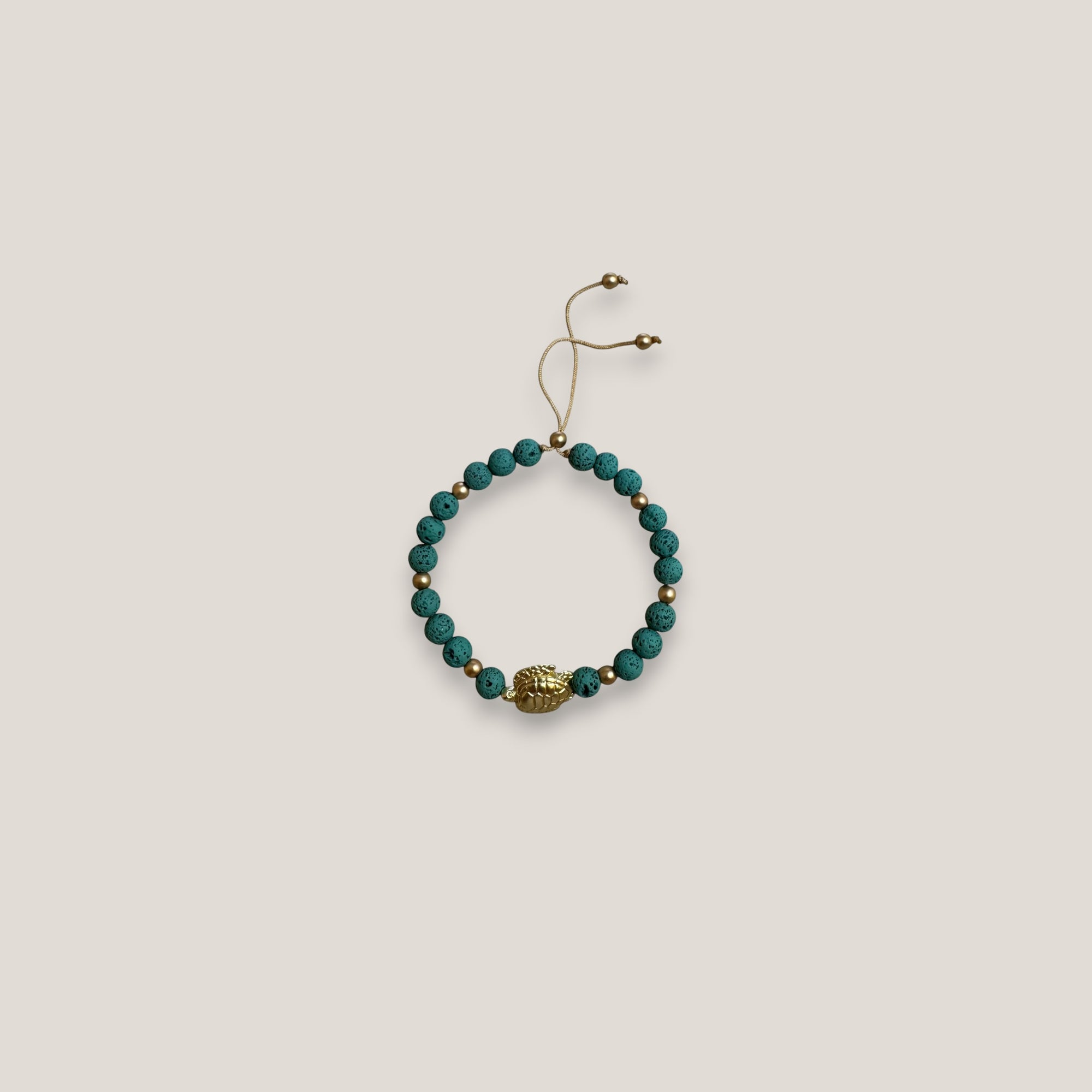 Armband mit einer großen goldenen Schildkröte und aquagrüner Lava