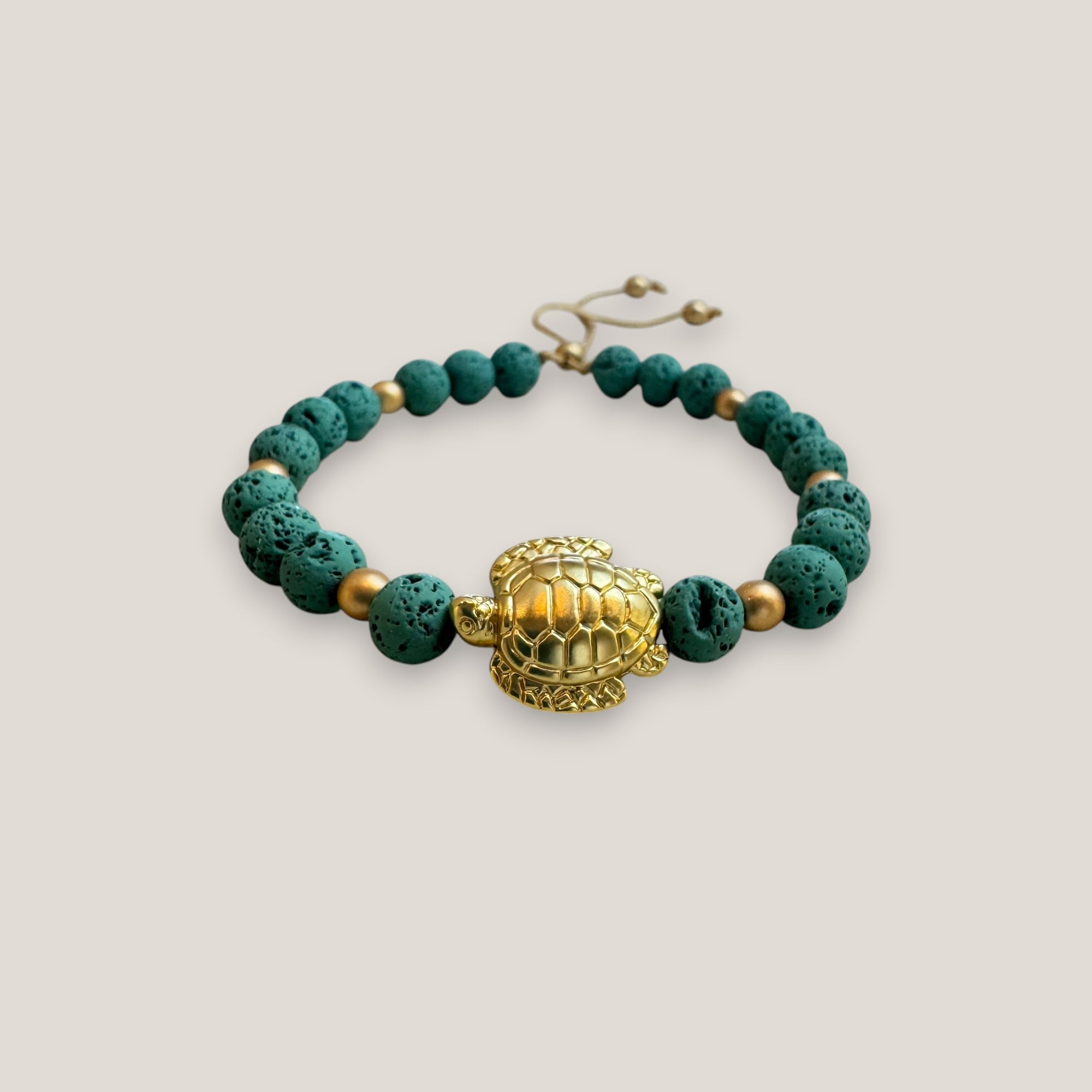 Armband mit einer großen goldenen Schildkröte und aquagrüner Lava