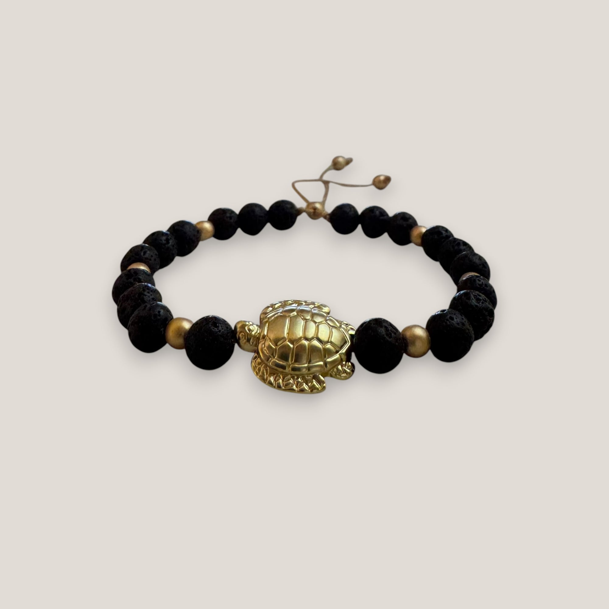 Pulsera con gran tortuga dorada lava negra