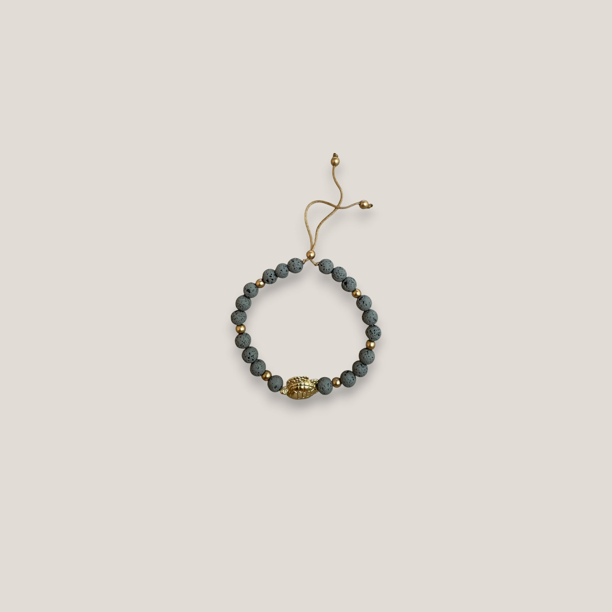 Pulsera con gran tortuga dorada lava gris claro