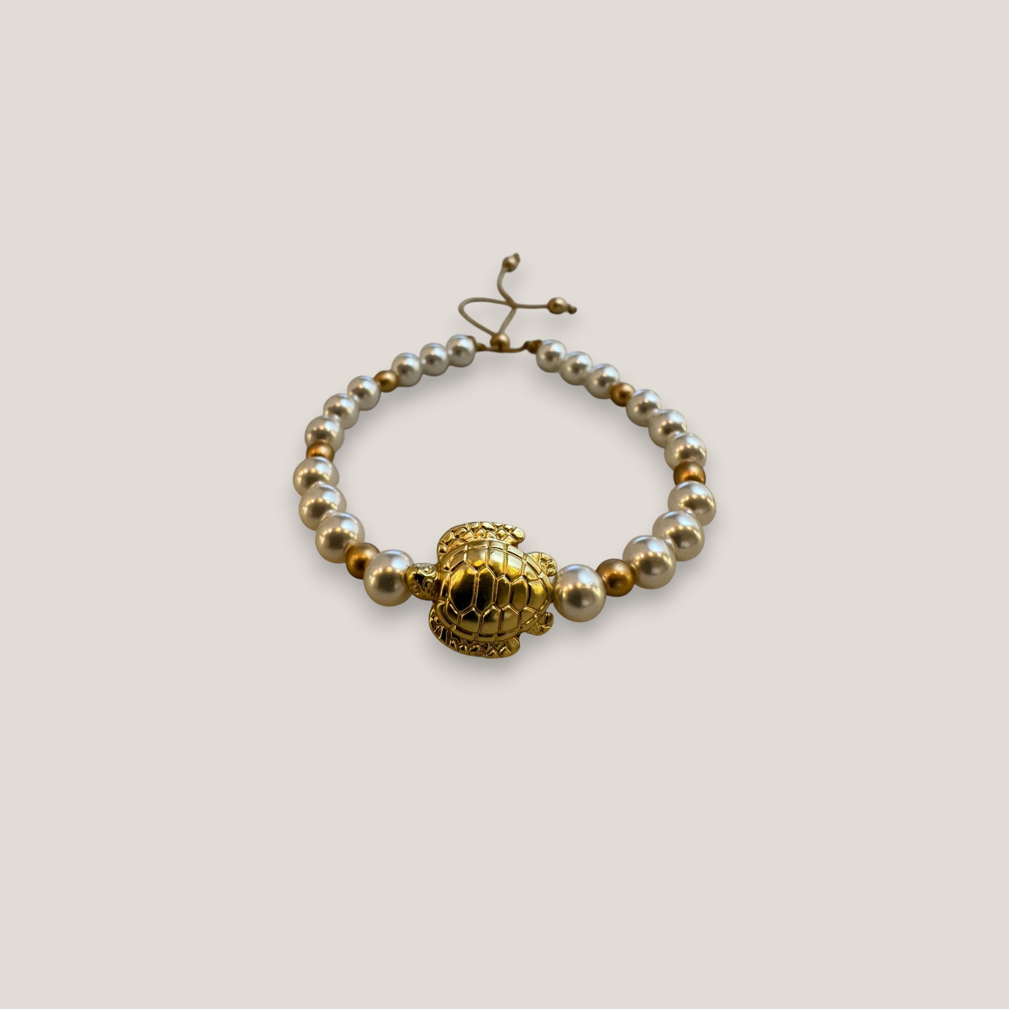 Armband mit großer goldener Schildkröte und weißen Perlmuttglasperlen