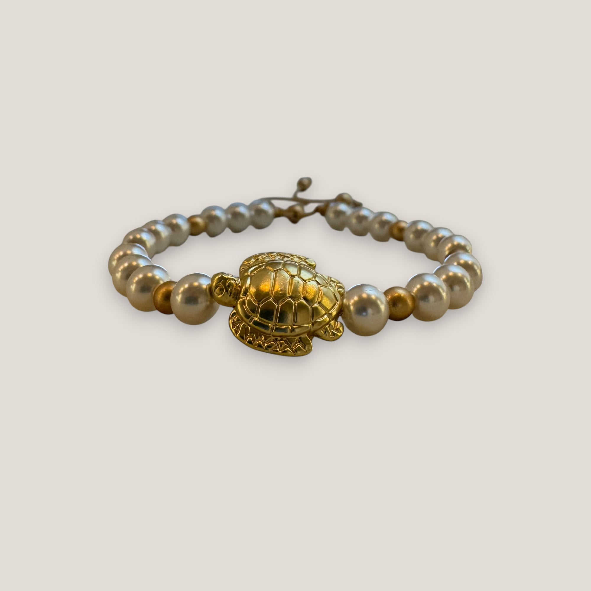 Armband mit großer goldener Schildkröte und weißen Perlmuttglasperlen