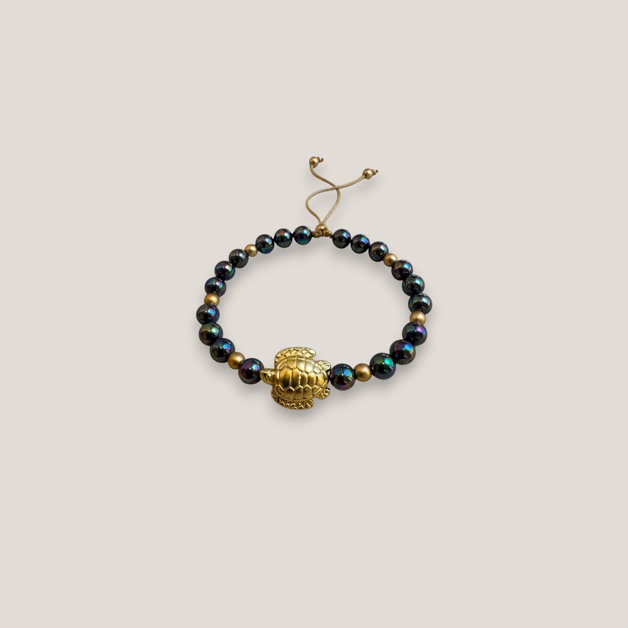 Pulsera con gran tortuga dorada perlas grises tornasoladas