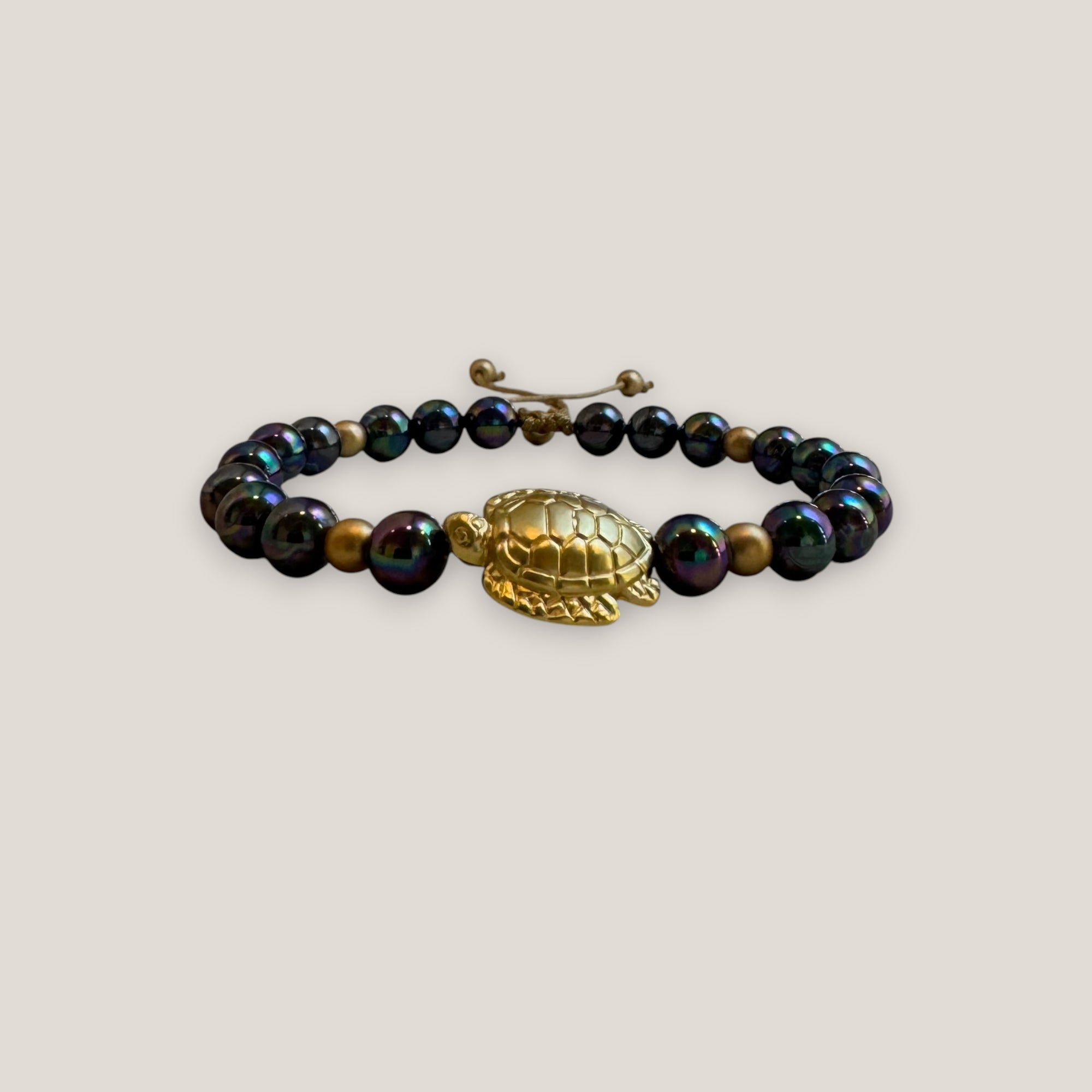 Pulsera con gran tortuga dorada perlas grises tornasoladas