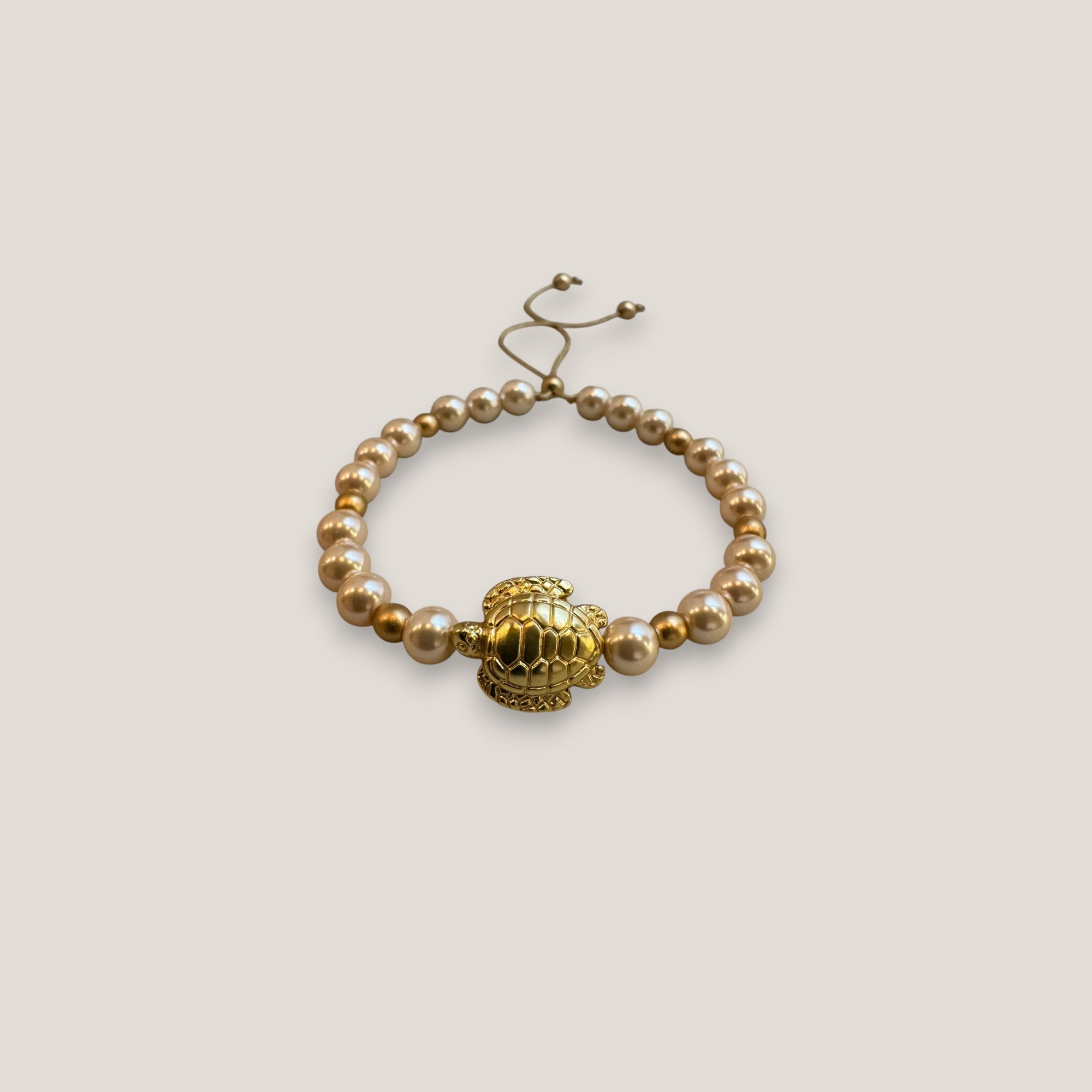 Armband mit großer goldener Schildkröte und rosa Perlen