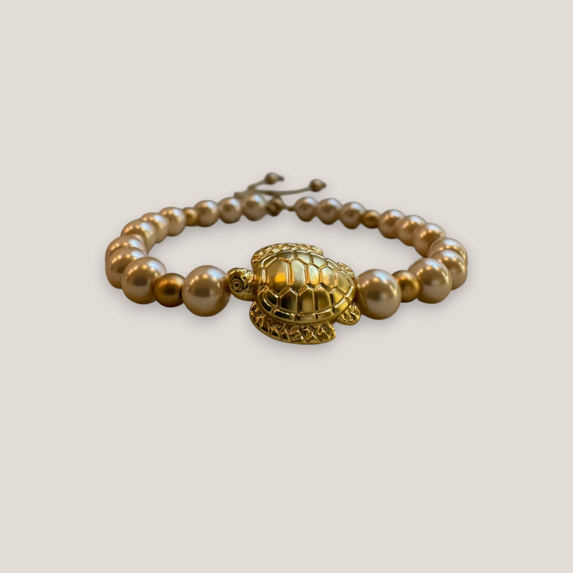 Armband mit großer goldener Schildkröte und rosa Perlen