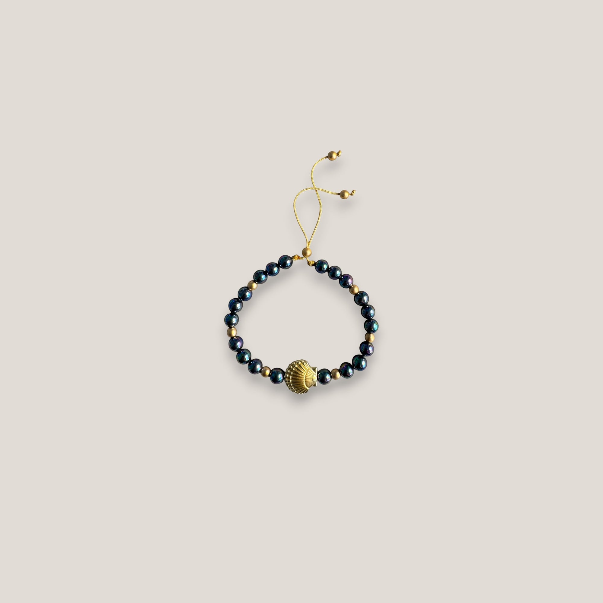 Pulsera con gran concha dorada perlas grises tornasoladas