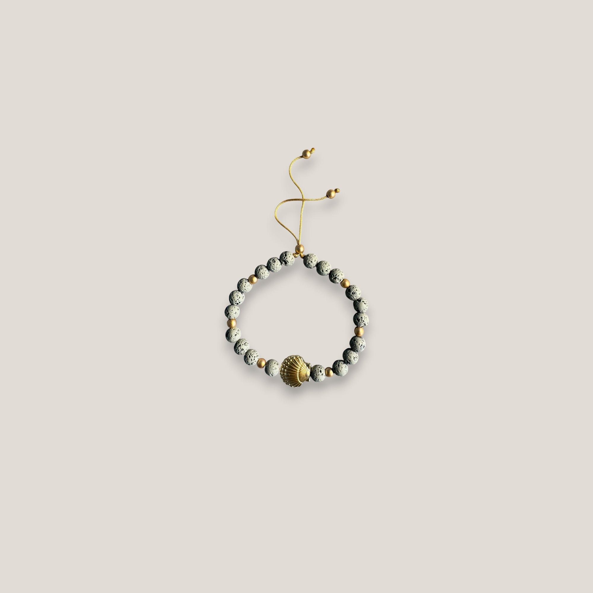 Armband mit großer goldener Muschel und grauer Lava