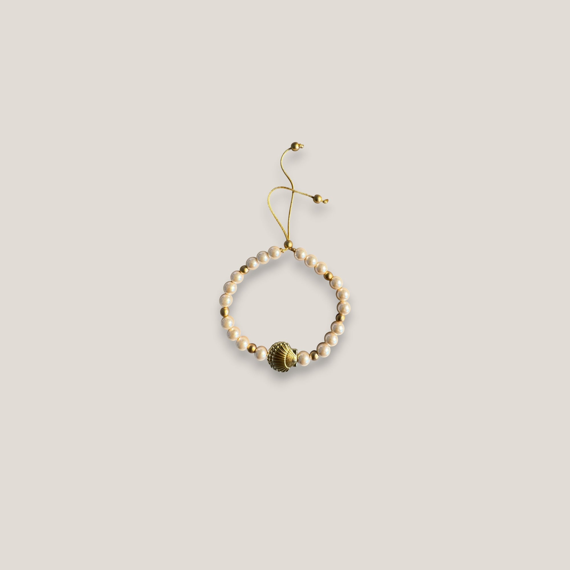 Pulsera con gran concha dorada perlas rosadas