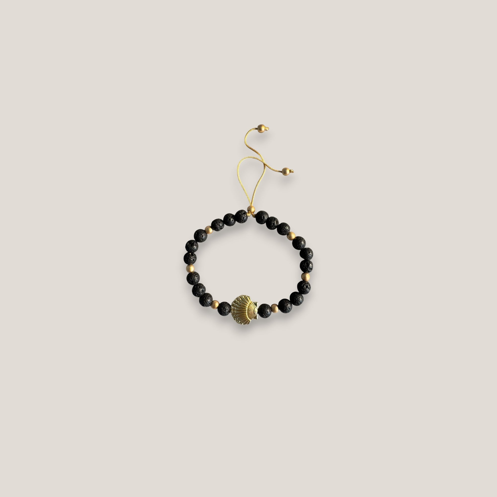 Armband mit großer goldener Muschel und schwarzer Lava