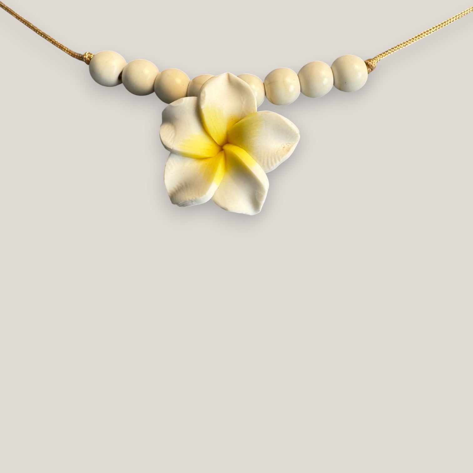 Collar midi flor Plumeria blanca amarilla howlitas naturales