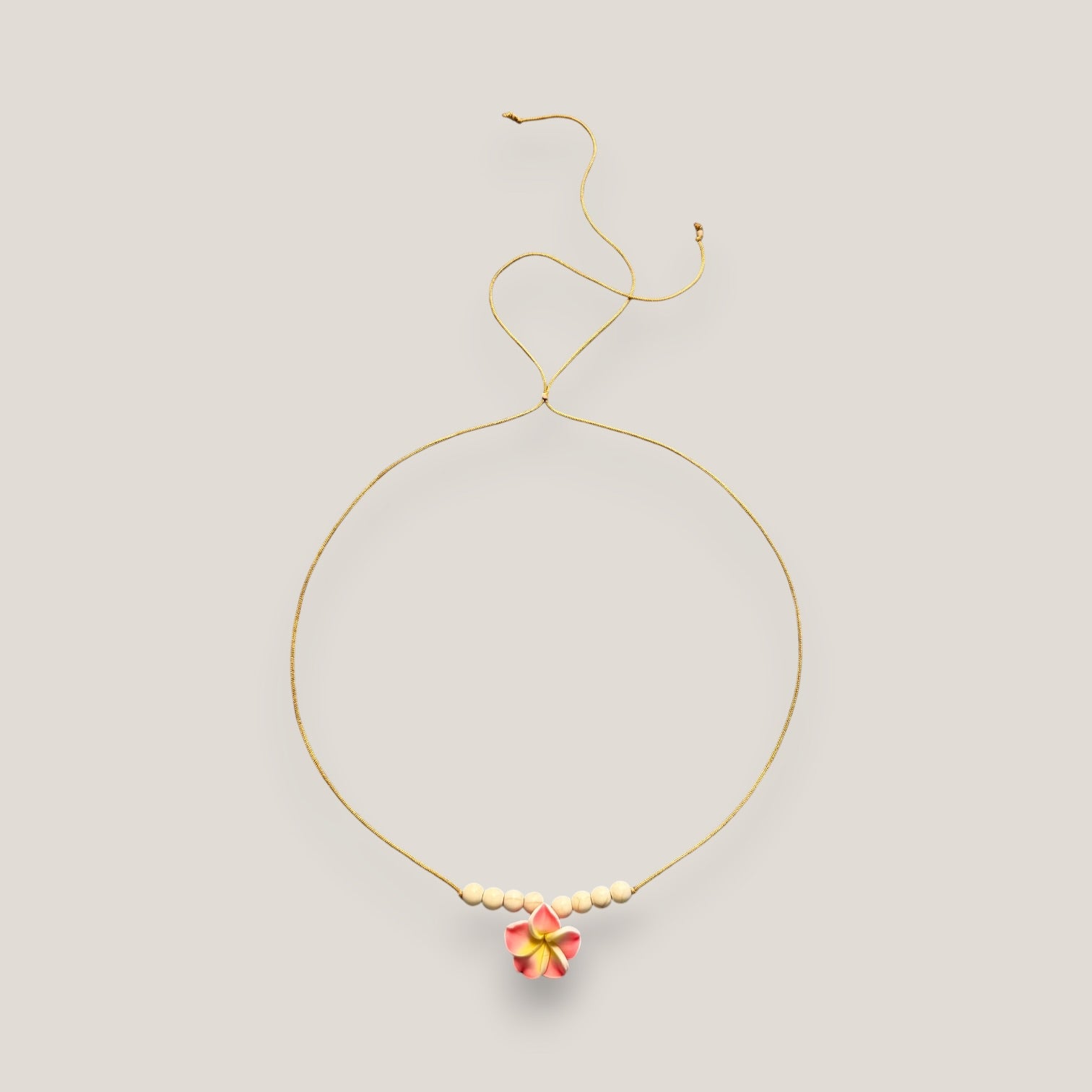 Collar midi flor Plumeria rosa amarilla howlitas naturales