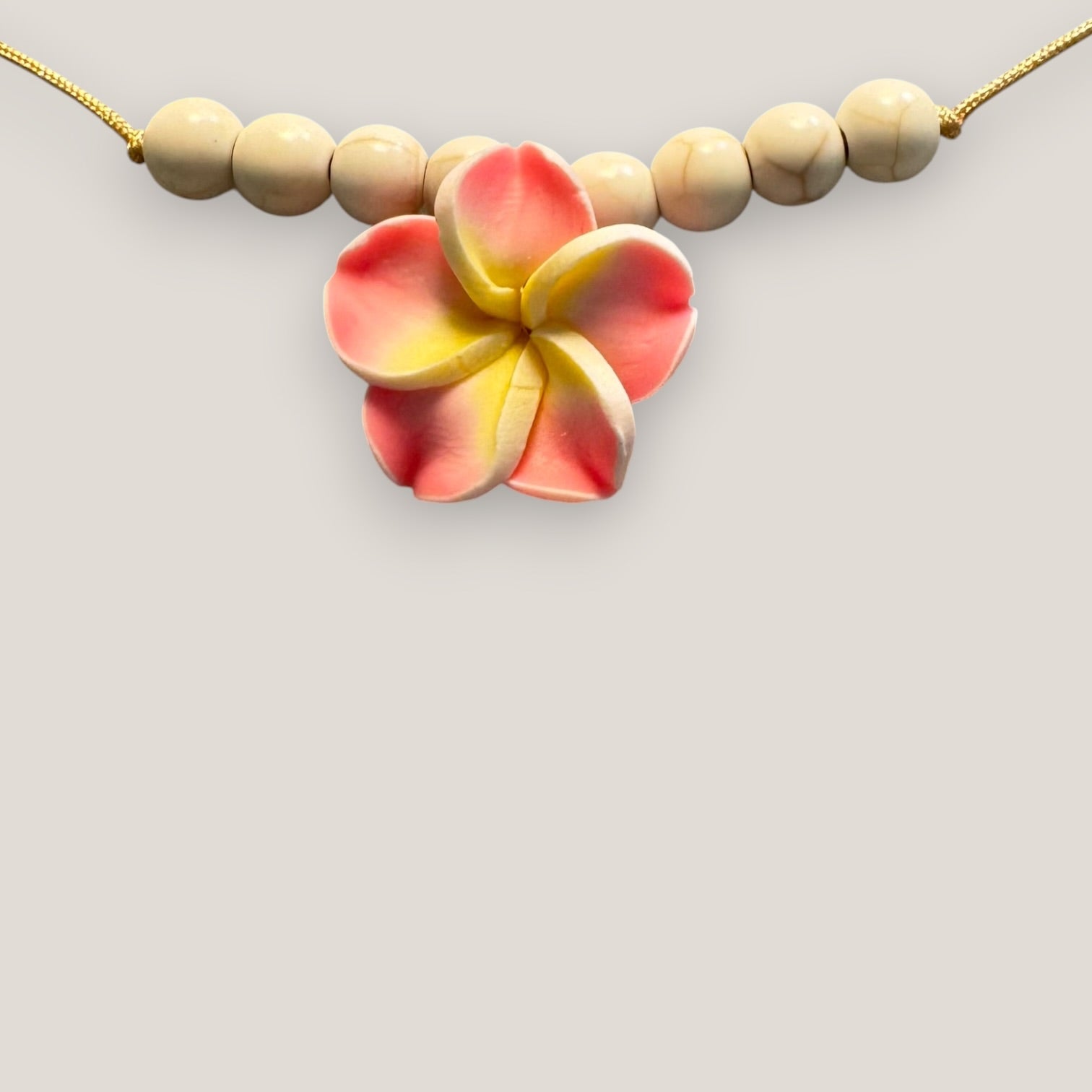 Collar midi flor Plumeria rosa amarilla howlitas naturales
