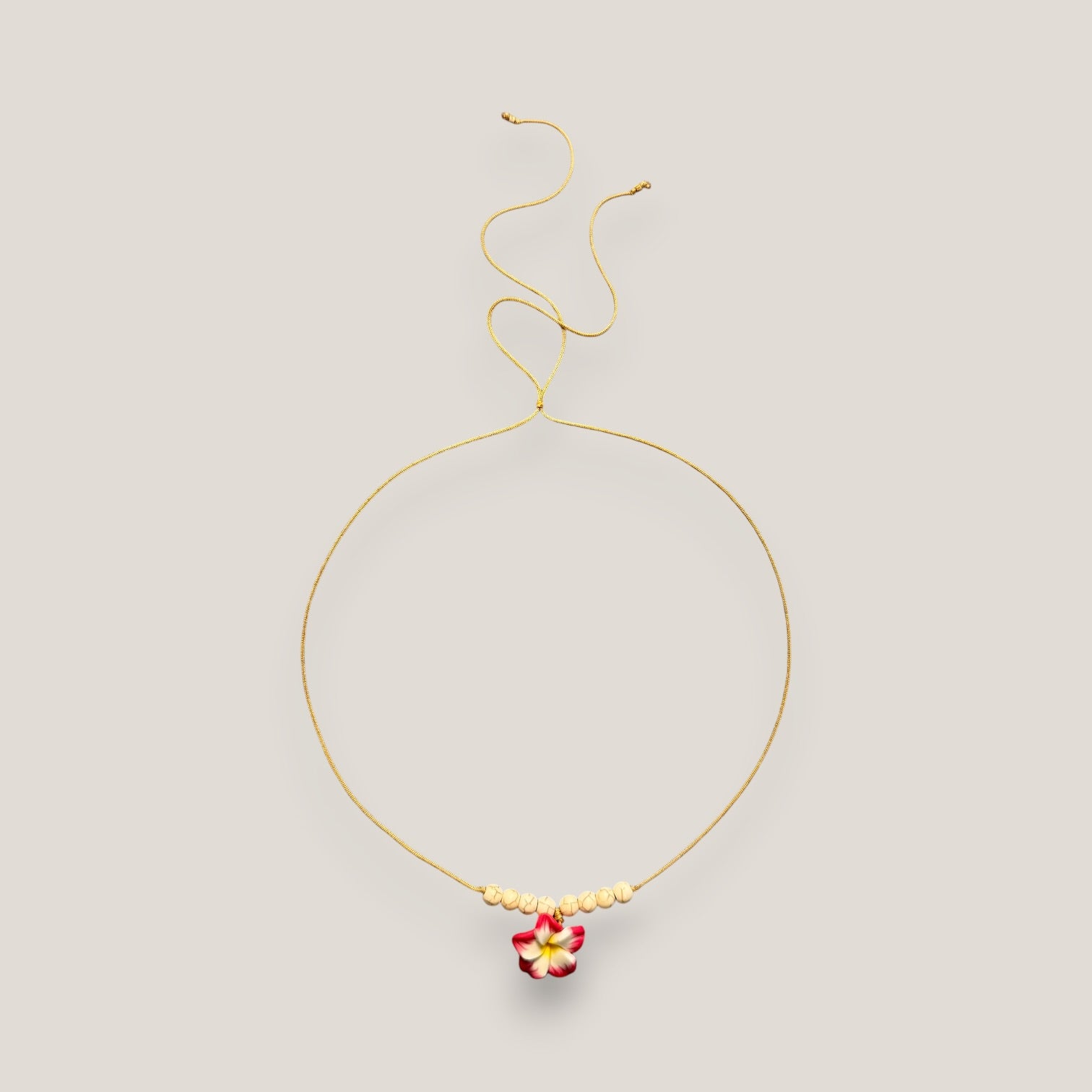 Collar midi flor Plumeria fucsia amarilla howlitas naturales