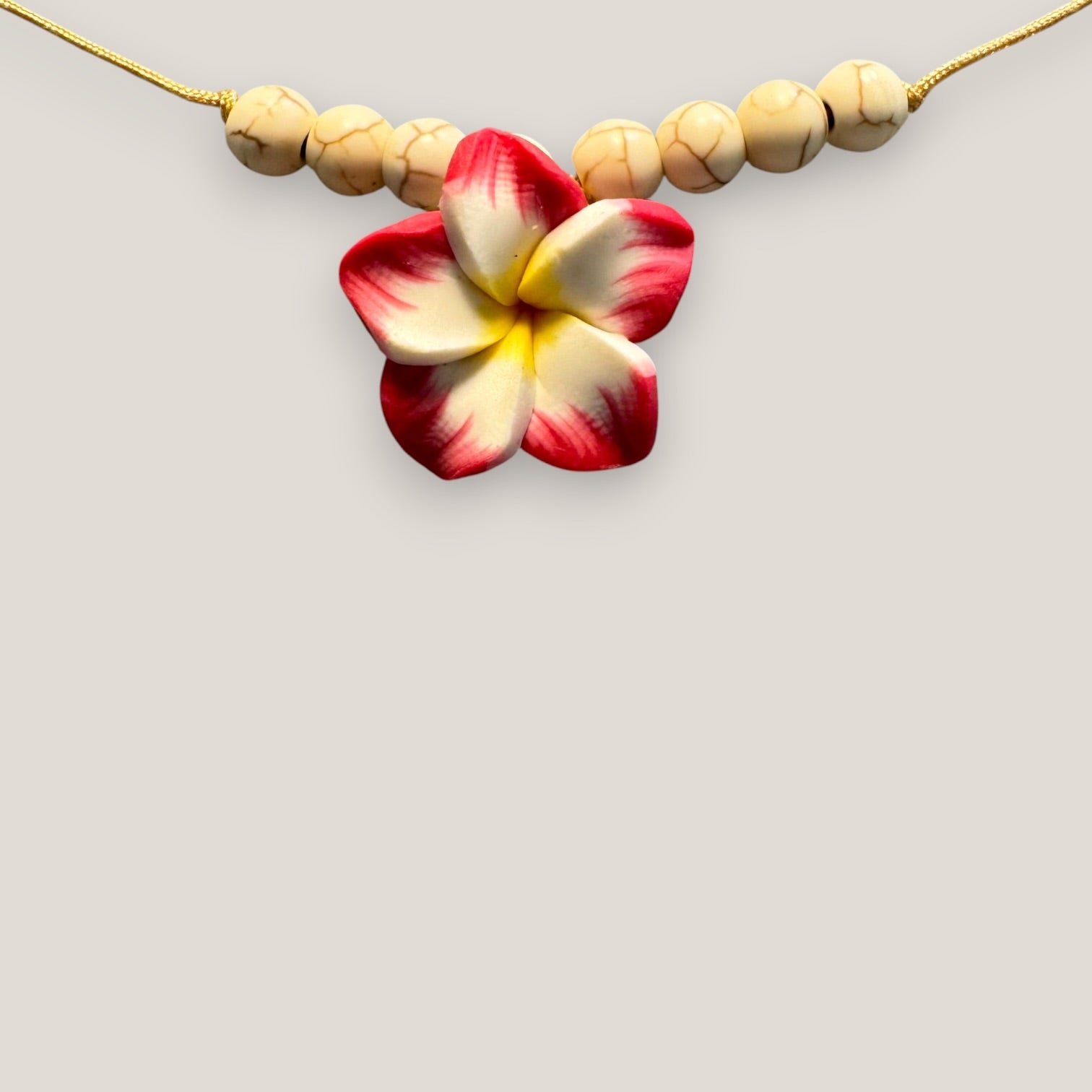 Collar midi flor Plumeria fucsia amarilla howlitas naturales