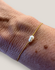 Pulsera minimal con perla natural alargada blanca irregular