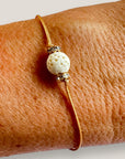 Pulsera minimal con bola esponja coral blanco y cuentas doradas con brillis lux blancos