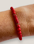 Pulsera con tubo, cuentas de lava roja y brillis oro con cristalitos rojos