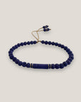 Pulsera con tubo, cuentas de lava azul profundo y brillis oro con cristalitos azules