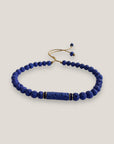 Pulsera con tubo, cuentas de lava en azulón y brillis oro con cristalitos azules